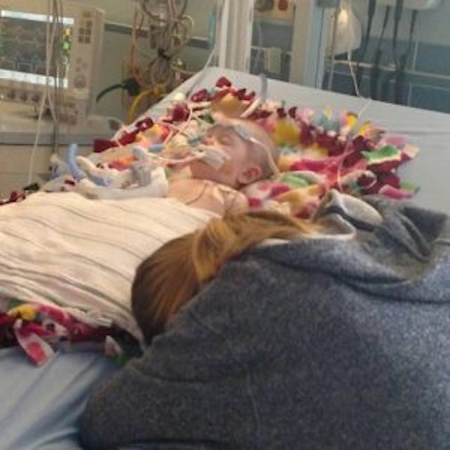 Sierra Hunt prays at baby Christa’s bedside. photo via Facebook