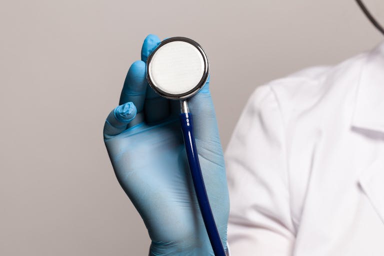 Close-up of female doctor using stethoscope, focus on stethoscope