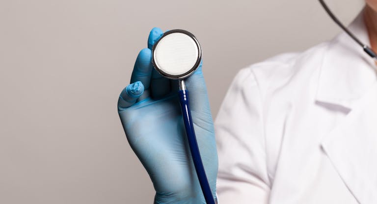 Close-up of female doctor using stethoscope, focus on stethoscope
