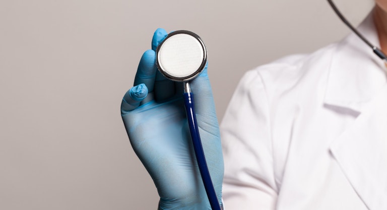 Close-up of female doctor using stethoscope, focus on stethoscope