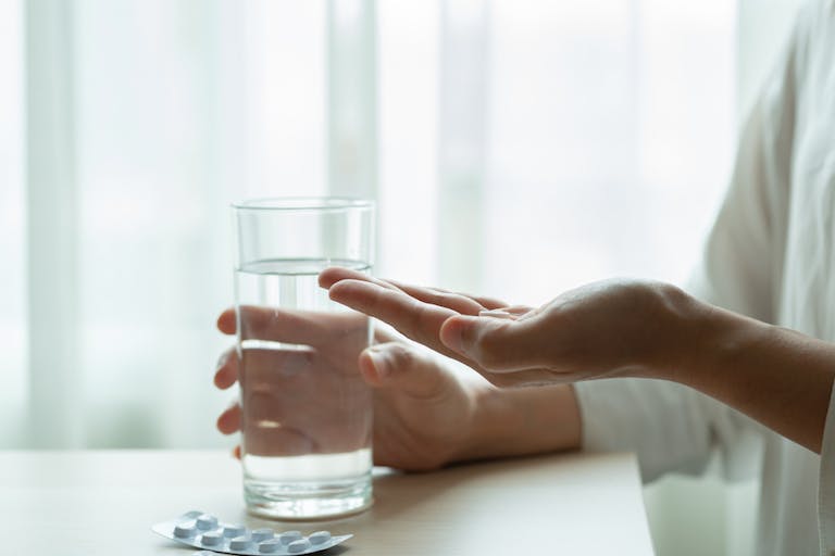 depressed women hand hold medicine with a glass of water, healthcare and medicine recovery concept