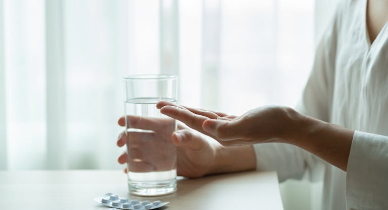 depressed women hand hold medicine with a glass of water, healthcare and medicine recovery concept