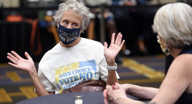 Jeri Swinton wears a mask reading “Forever the Free State” as she talks to friends during the pro-choice Kansas for Constitutional Freedom primary election watch party in Overland Park, Kansas August 2, 2022. – Voters headed to the polls in the Midwestern US state of Kansas Tuesday to weigh in on the first major ballot on abortion since the Supreme Court ended the national right to the procedure in June. (Photo by DAVE KAUP / AFP) (Photo by DAVE KAUP/AFP via Getty Images) Jeri Swinton wears a mask reading “Forever the Free State” as she talks to friends during the pro-choice Kansas for Constitutional Freedom primary election watch party in Overland Park, Kansas August 2, 2022. – Voters headed to the polls in the Midwestern US state of Kansas Tuesday to weigh in on the first major ballot on abortion since the Supreme Court ended the national right to the procedure in June. (Photo by DAVE KAUP / AFP) (Photo by DAVE KAUP/AFP via Getty Images)