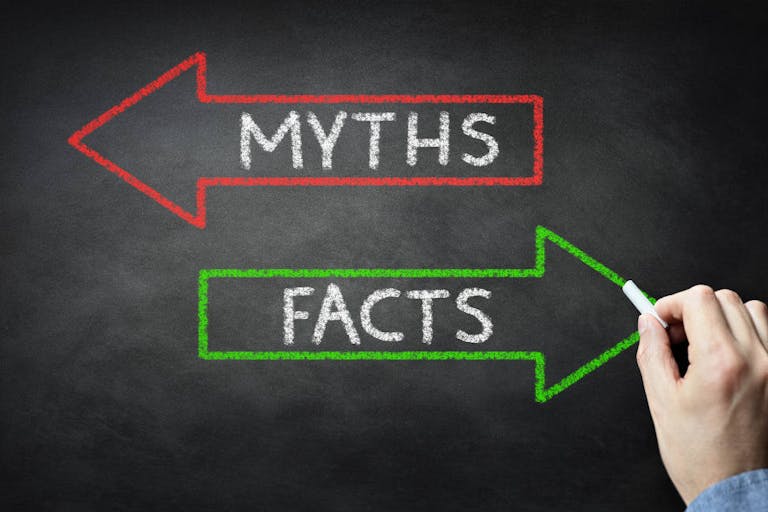 Businessman drawing Myths or Facts on blackboard