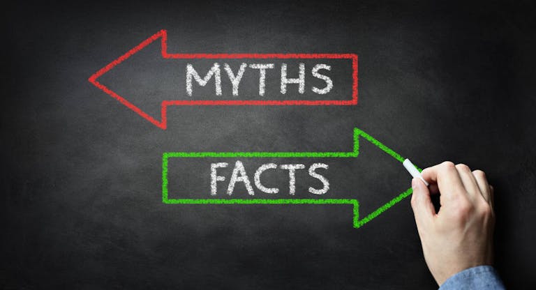 Businessman drawing Myths or Facts on blackboard