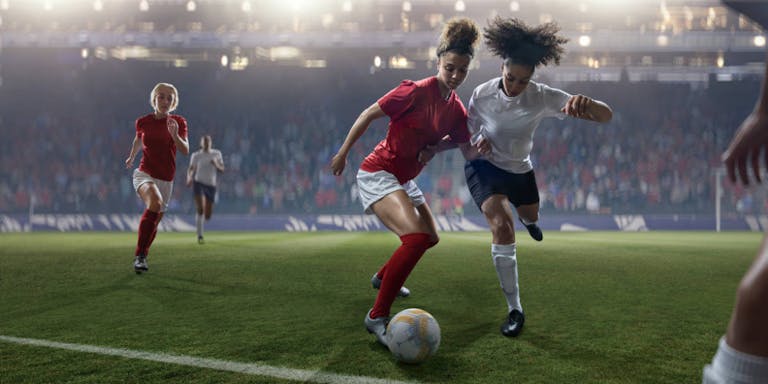 Professional Women Soccer Player Dribbling Ball Past Rival During Match