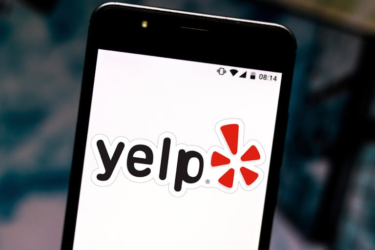 In this photo illustration the Yelp logo is seen displayed