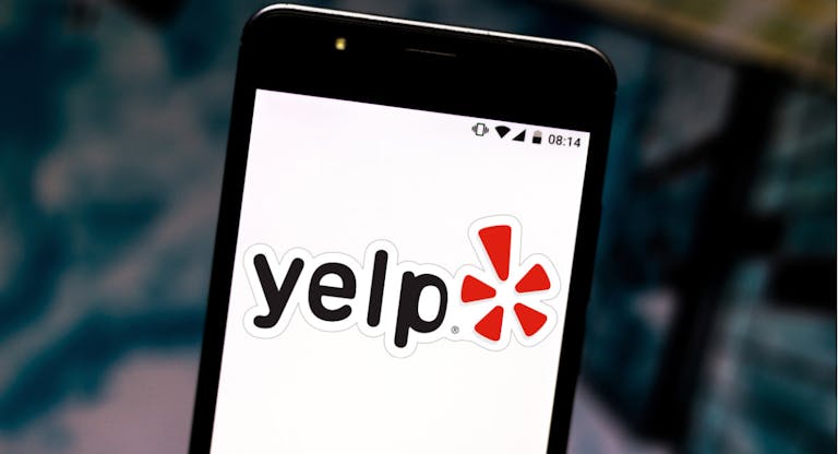 In this photo illustration the Yelp logo is seen displayed