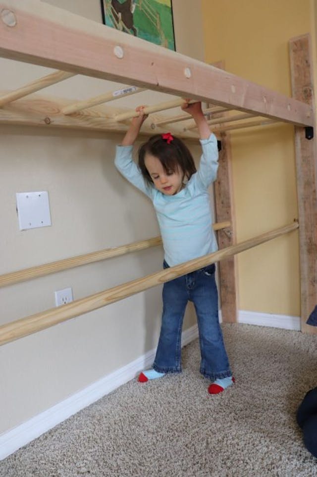 Melody practicing walking with her monkey bars built by her dad. Photo courtesy of Thenhaus family. trisomy 18