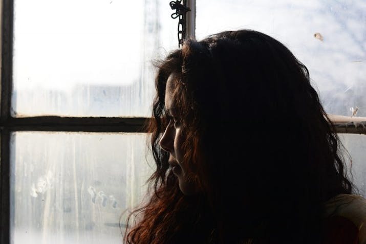 sad woman looking out window