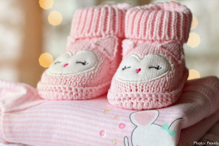 Photo: Pexels.com/Pixabay Photo shows pink baby booties on top of a pink baby blanket