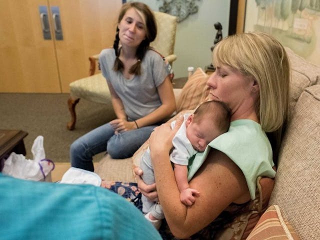 Lauren holds her new adopted baby boy as his birth mother looks on. Copyright Sara Liz Photography. Lauren holds her new adopted baby boy as his birth mother looks on. Copyright Sara Liz Photography.