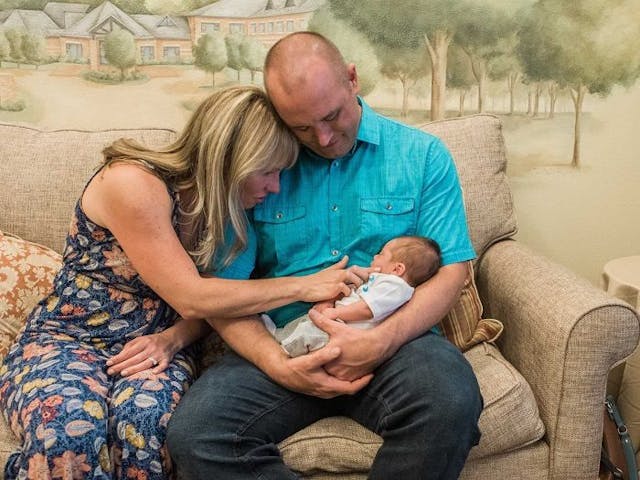 Lauren and her husband hold their newly adopted son. Copyright Sara Liz Photography.