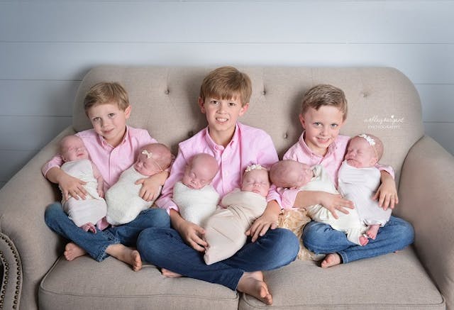 Proud big brothers hold newborn sextuplets after their parents refused selective reduction abortion. Photo copyright Ashley Sargent Photography, LLC. chose life
