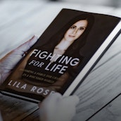 Hands holding Lila Rose's book
