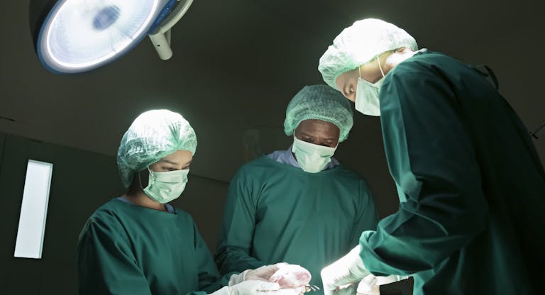 Surgeons are performing heart transplant operation for a serious patient.