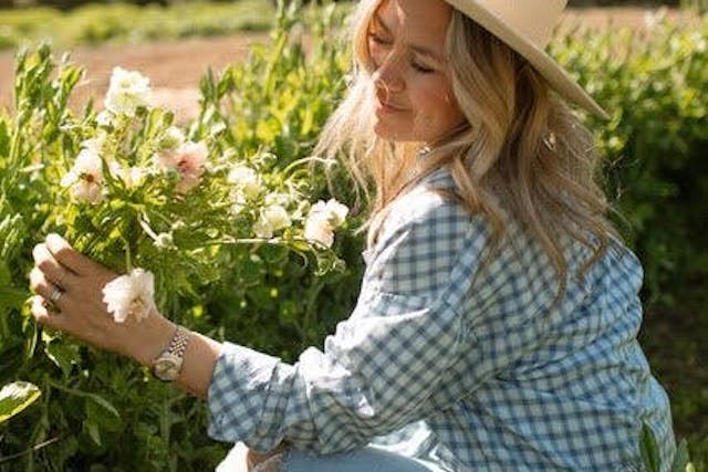 Woman in a hat picking flowers