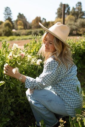 Woman in a hat picking flowers