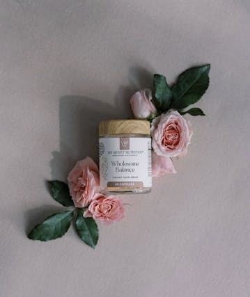Pink flowers around a jar of supplements