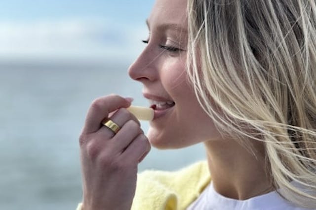 A woman putting on chapstick