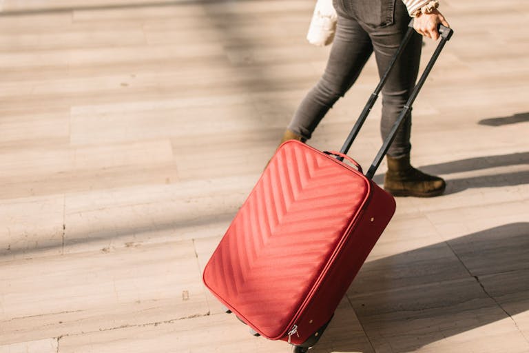 A woman pulling a pink suitcase
