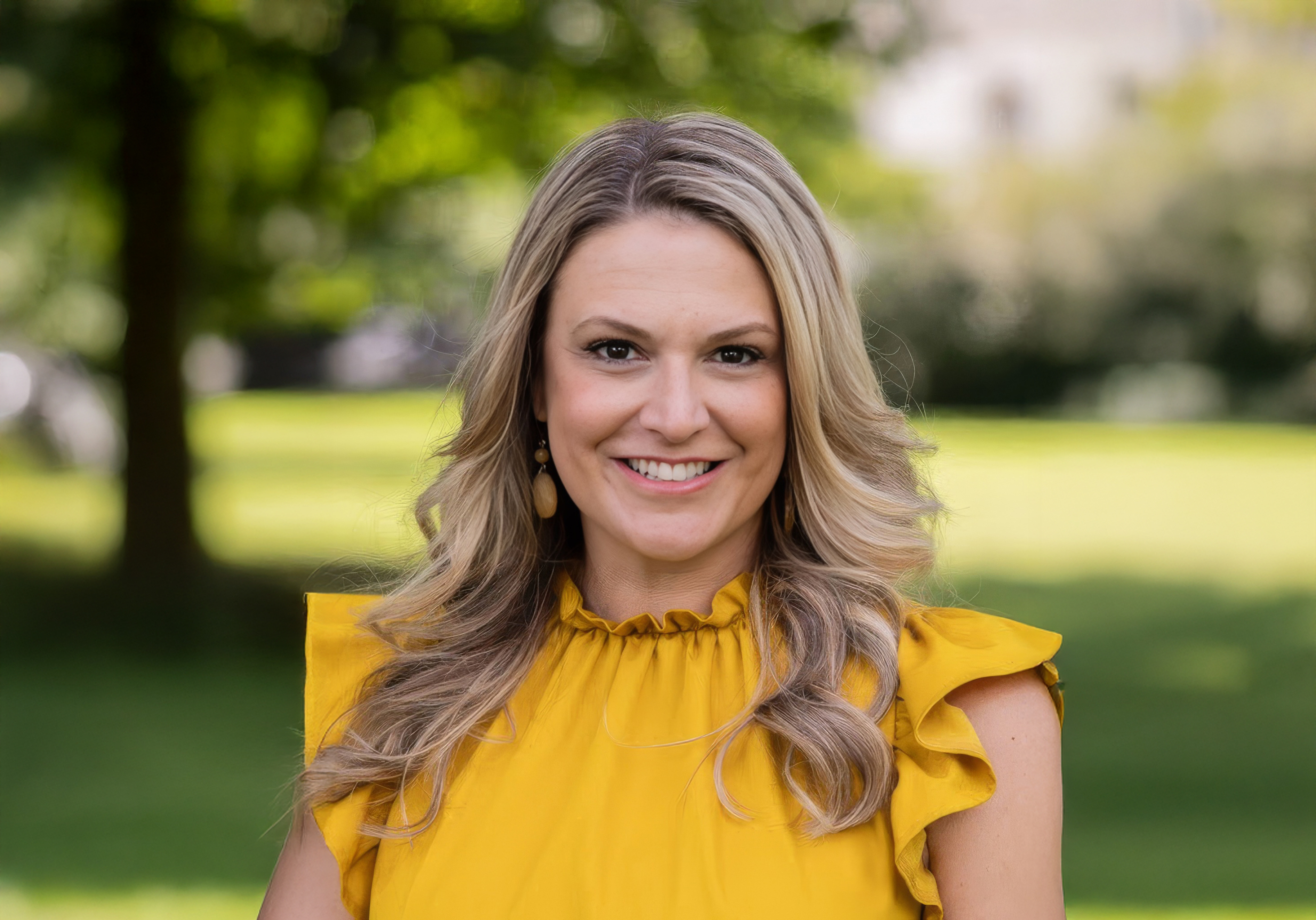 Blonde woman in yellow blouse at park