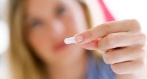 Depressed young woman taking pills at home.