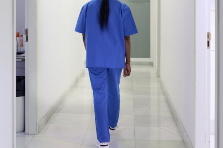 Photo: Tempura/Getty Images A nurse walks down the hospital corridor first thing in the morning.
