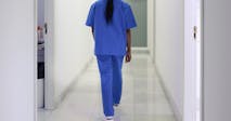 A nurse walks down the hospital corridor first thing in the morning.