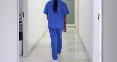 A nurse walks down the hospital corridor first thing in the morning.