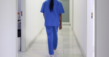 A nurse walks down the hospital corridor first thing in the morning.