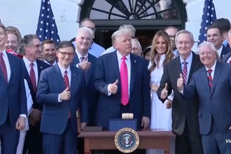 Trump gives a thumbs up after signing reconciliation bill surrounded by his wife Melania and federal legislators. The bill defunds Planned Parenthood for one year.