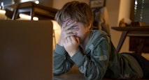 Young kid looking movies on the laptop