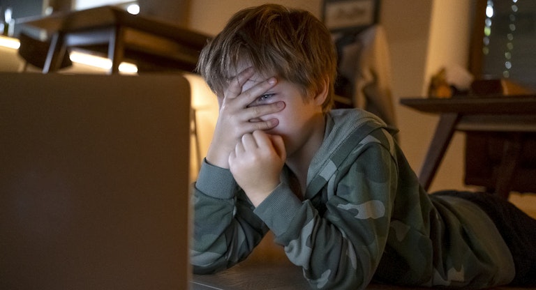 Young kid looking movies on the laptop