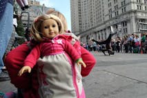 A girl with her doll peeking out of her backpack watches as a street entertainer dances during a road side show in New York on October 9, 2015. AFP PHOTO/JEWEL SAMAD (Photo credit should read JEWEL SAMAD/AFP via Getty Images) US-STREET-ENTERTAINMENT