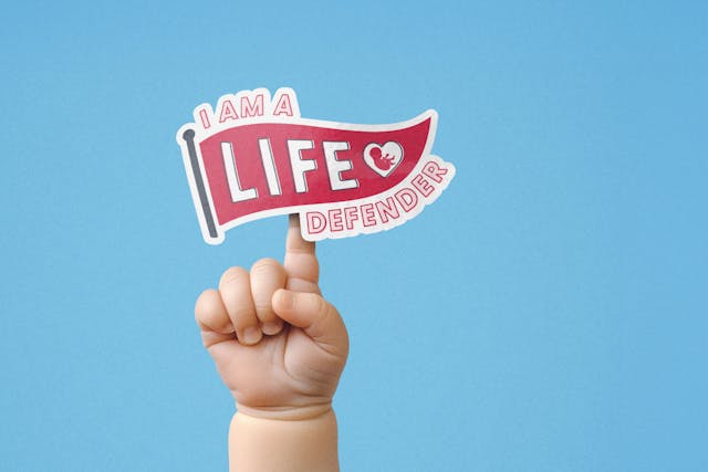A baby hand with index finger pointing up