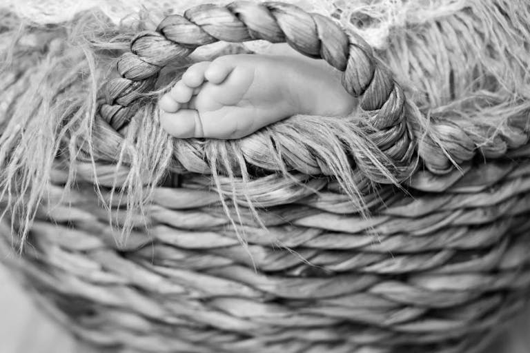 Photo: Getty Images Close up picture of new born baby feet on a white plaid in the wicker basket
