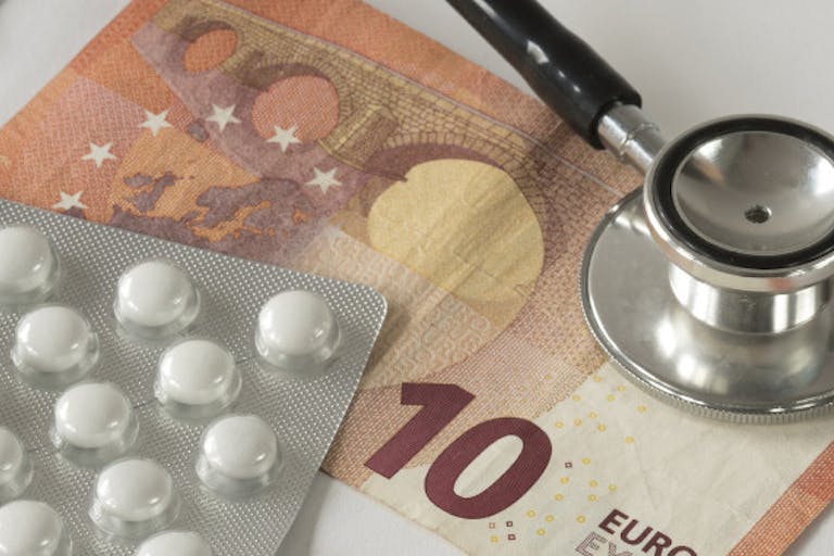 flat lay heap of medicines Assorted pharmaceutical medicine pills, tablets, stethoscope and money against white background