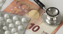 Assorted pharmaceutical medicine pills, tablets, stethoscope and money against white background