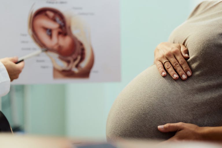 Close up of unrecognizable pregnant woman having an appointment at her gynecologists.