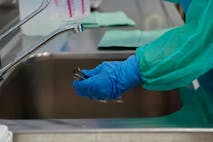 medical staff at faucet with rubber gloves