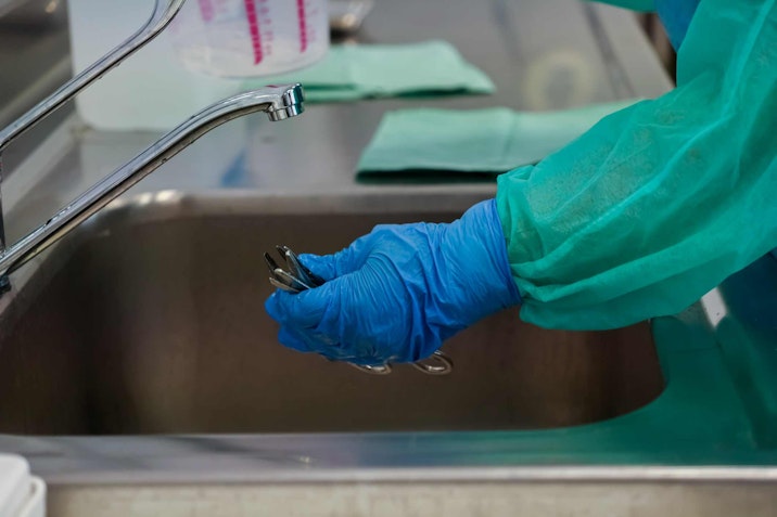 medical staff at faucet with rubber gloves