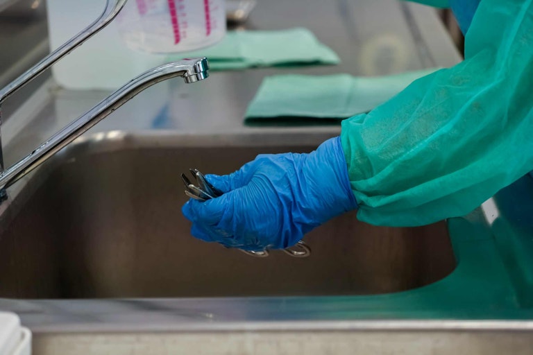 medical staff at faucet with rubber gloves