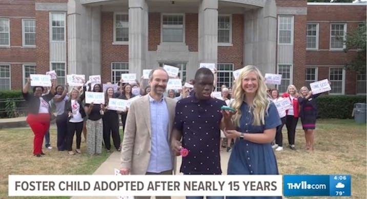 Cozy with his parents Tim and Anna Dietrich as people behind them celebrate his adoption.