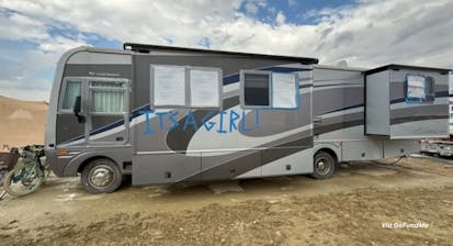 An RV parked at Burning Man, with the words, "It's a Girl!"