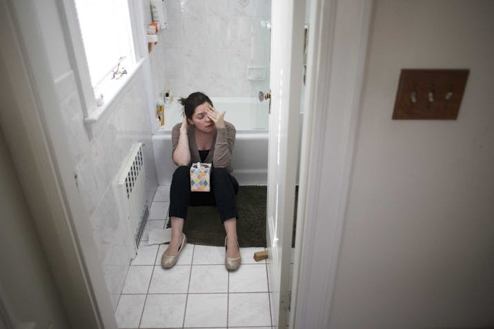 Photo: Getty Images Pregnant Woman Sitting on Bathroom Floor with Box of Tissues between Knees