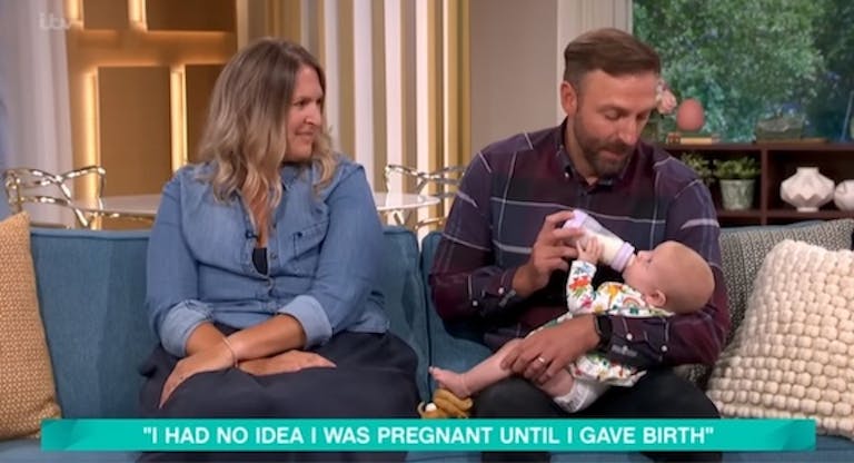 Helen watches as Michael feeds baby Olivia her bottle.
