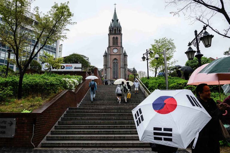 Photo by ANTHONY WALLACE/AFP via Getty Images People walk up the stairs towards Myeongdong Cathedral in Seoul on April 22, 2025, a day after the death of Pope Francis. Pope Francis died of a stroke, the Vatican announced hours after the death on April 21 of the 88-year-old reformer who inspired devotion but riled traditionalists during 12 years leading the Catholic Church. (Photo by ANTHONY WALLACE / AFP)