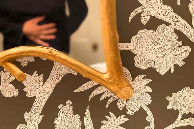 Photo: Getty Images mid adult woman clutches stomach