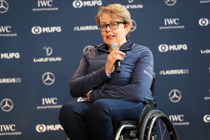 Photo: Getty Images A woman in a wheelchair holds a microphone and gives a speech on stage.